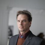 Portrait of a businessman in a formal suit in an indoor setting.